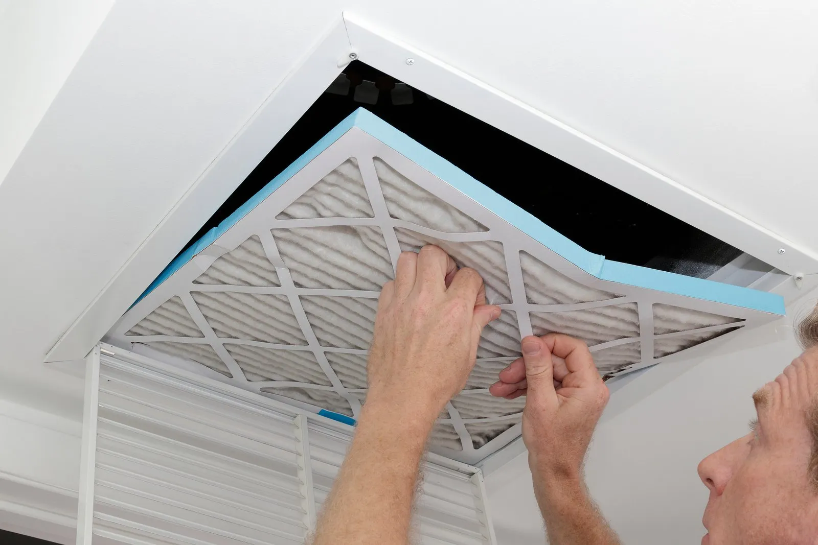 Technician cleaning an air duct vent in a Baymeadows home